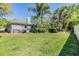 Spacious backyard featuring a lush green lawn, mature trees, and a cozy patio area at 9302 Deer Creek Dr, Tampa, FL 33647