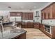Spacious kitchen with wood cabinets, granite countertops, stainless steel appliances, and plank flooring at 9302 Deer Creek Dr, Tampa, FL 33647