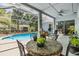 Relaxing screened patio with a table and chairs, adjacent to a sparkling blue swimming pool at 9302 Deer Creek Dr, Tampa, FL 33647