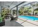 Spacious screened patio with exercise equipment and a dining area overlooks the sparkling pool at 9302 Deer Creek Dr, Tampa, FL 33647