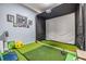 Indoor golf simulator room featuring a projector, putting green, and golf equipment at 9302 Deer Creek Dr, Tampa, FL 33647