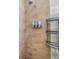 Close-up of a tiled shower wall with a showerhead, soap dispensers, and a wire rack at 9302 Deer Creek Dr, Tampa, FL 33647