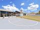 Backyard basketball court provides a fun activity space, plus patio and green backyard views at 9711 Wydella St, Riverview, FL 33569