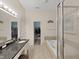 Bathroom featuring dual sinks, soaking tub and glass-enclosed shower and a large walk-in closet at 9711 Wydella St, Riverview, FL 33569