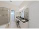 Well-lit bathroom with a double sink vanity, granite countertops, and glass enclosed shower, providing a luxurious experience at 9711 Wydella St, Riverview, FL 33569