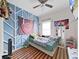 Stylized bedroom with blue accent wall, window, fan, and unique decorations at 9711 Wydella St, Riverview, FL 33569