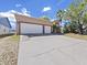 View of home with two-car garage, spacious driveway, and attractive landscaping at 9711 Wydella St, Riverview, FL 33569