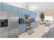 Bright kitchen featuring stainless steel appliances and charming blue cabinetry, offering a blend of style and functionality at 9711 Wydella St, Riverview, FL 33569