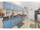 Kitchen featuring blue cabinets, granite countertops, stainless appliances and an open view to the living area at 9711 Wydella St, Riverview, FL 33569