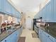 Kitchen featuring blue cabinets, stainless steel appliances, and granite countertops with a breakfast bar at 9711 Wydella St, Riverview, FL 33569