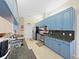 Kitchen featuring blue cabinets, granite countertops, and stainless steel appliances at 9711 Wydella St, Riverview, FL 33569