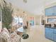 Bright kitchen featuring blue cabinets, granite countertops, and adjacent breakfast nook with a glass table at 9711 Wydella St, Riverview, FL 33569