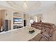 Living room with tile flooring, built-in shelving with a TV, and a comfortable brown sectional sofa at 9711 Wydella St, Riverview, FL 33569