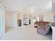 Open-concept living room with tile floors, built-in entertainment center, and a brown leather sectional sofa at 9711 Wydella St, Riverview, FL 33569