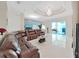 Spacious living room featuring tile floors, chandelier, and a comfortable brown leather sectional sofa at 9711 Wydella St, Riverview, FL 33569