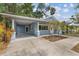 Charming blue home featuring a covered parking area and well-manicured landscaping at 1039 23Rd St, Sarasota, FL 34234