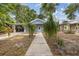 Inviting light blue home with lush front yard landscaping and walkway at 1039 23Rd St, Sarasota, FL 34234