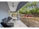 Covered patio with comfortable seating overlooks a backyard with a fire pit area at 1039 23Rd St, Sarasota, FL 34234