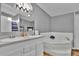 Well-lit bathroom featuring a soaking tub, double vanity, and modern fixtures for a spa-like experience at 10404 Hawk Ct, Riverview, FL 33578