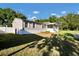 Single-story home with gray siding, white trim, screened porch, and neatly landscaped front yard at 10404 Hawk Ct, Riverview, FL 33578