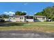 Exterior view of the home with a covered front porch and well-maintained lawn at 10404 Hawk Ct, Riverview, FL 33578