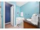 Bright bathroom featuring a soaking tub, single sink vanity, and blue accent wall at 12442 Curry Dr, Spring Hill, FL 34609