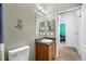 This is a bathroom view, showing a toilet, sink with vanity and an open doorway to a bedroom at 12442 Curry Dr, Spring Hill, FL 34609