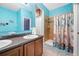 Bathroom featuring double sink vanity and a glass enclosed shower with ocean themed shower curtain at 12442 Curry Dr, Spring Hill, FL 34609