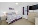 Bedroom with neutral carpet, ceiling fan, dresser, and purple accents throughout at 12442 Curry Dr, Spring Hill, FL 34609