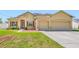 Charming, single-story home featuring stucco siding, a manicured lawn, and a two-car garage at 12442 Curry Dr, Spring Hill, FL 34609