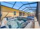 This is an outdoor hot tub, surrounded by an enclosed patio with a pool in the background at 12442 Curry Dr, Spring Hill, FL 34609