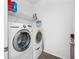 Laundry room with front loading washer, dryer and shelving at 12442 Curry Dr, Spring Hill, FL 34609