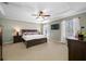 Spacious main bedroom featuring a king-size bed, tray ceiling, and large windows at 12442 Curry Dr, Spring Hill, FL 34609