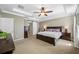 Main bedroom boasts a tray ceiling, large bed, and closet with a barn door entrance at 12442 Curry Dr, Spring Hill, FL 34609