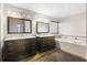 Elegant bathroom with dual vanities, modern lighting, and a luxurious tub for a relaxing spa-like experience at 12929 Prestwick Dr, Riverview, FL 33579