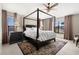 Primary bedroom with a four-poster bed, side tables, and large windows providing lots of natural light at 12929 Prestwick Dr, Riverview, FL 33579