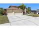Spacious driveway leading to a two-car garage, surrounded by well-maintained landscaping at 12929 Prestwick Dr, Riverview, FL 33579