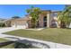 Charming two-story home with a manicured lawn and a beautiful mature tree in the front yard at 12929 Prestwick Dr, Riverview, FL 33579