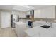 Modern kitchen with white cabinets, stainless steel appliances, a center island, and marble countertops at 12929 Prestwick Dr, Riverview, FL 33579