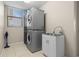 Functional laundry room with stacked washer and dryer, utility sink, and bright overhead lighting at 12929 Prestwick Dr, Riverview, FL 33579