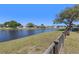 Backyard pond view with lush green landscaping and neighboring homes across the water at 12929 Prestwick Dr, Riverview, FL 33579