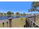Backyard pond view from a wooden gate with lush green landscaping and neighboring homes across the water at 12929 Prestwick Dr, Riverview, FL 33579