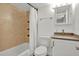 Updated bathroom features a shower/tub combo with neutral tile, open wood shelving and granite vanity at 1301 S Howard Ave # B24, Tampa, FL 33606
