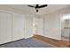 Bedroom features hardwood floors, ceiling fan, double closet doors and doorway to adjoining bathroom at 1301 S Howard Ave # B24, Tampa, FL 33606