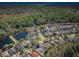 An aerial view shows homes in a community near a lush green forest and small body of water at 15925 Pond Rush Ct, Land O Lakes, FL 34638