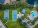 Aerial view shows tennis court, basketball court, pool, park area, and community amenities at 15925 Pond Rush Ct, Land O Lakes, FL 34638