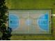 An aerial view showcases a well-maintained basketball court with grass and trees at 15925 Pond Rush Ct, Land O Lakes, FL 34638