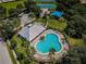 Aerial view showcasing a community pool, cabana, playground, tennis court, all nestled within lush landscaping at 15925 Pond Rush Ct, Land O Lakes, FL 34638