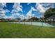 A view of the fenced in community basketball court with landscaping and grass at 15925 Pond Rush Ct, Land O Lakes, FL 34638