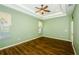 Bedroom featuring a tray ceiling, ceiling fan, wood floors, and natural light at 15925 Pond Rush Ct, Land O Lakes, FL 34638